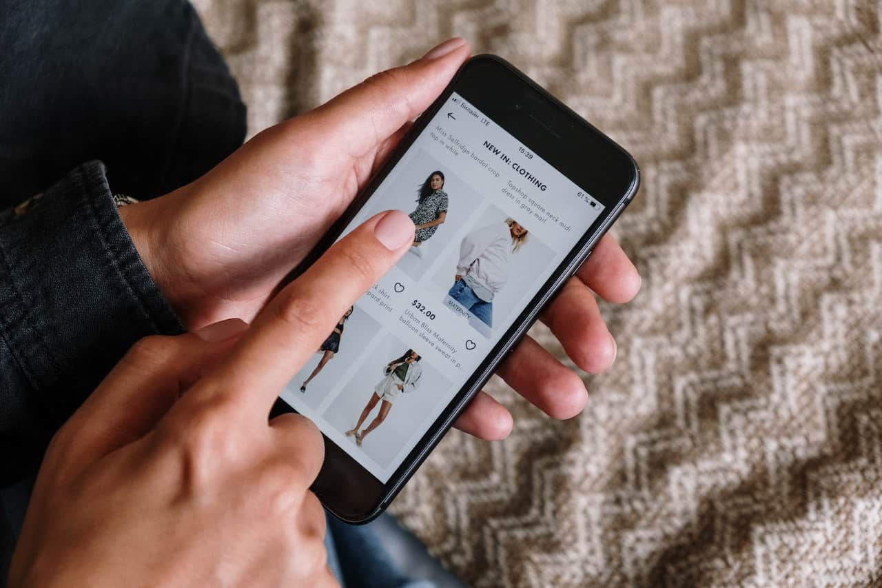 A person browsing clothes on an e-commerce website on their phone.